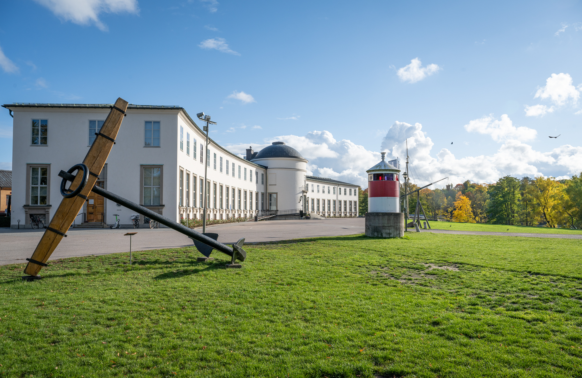 Stor vit byggnad med höstträd i bakgrunden 