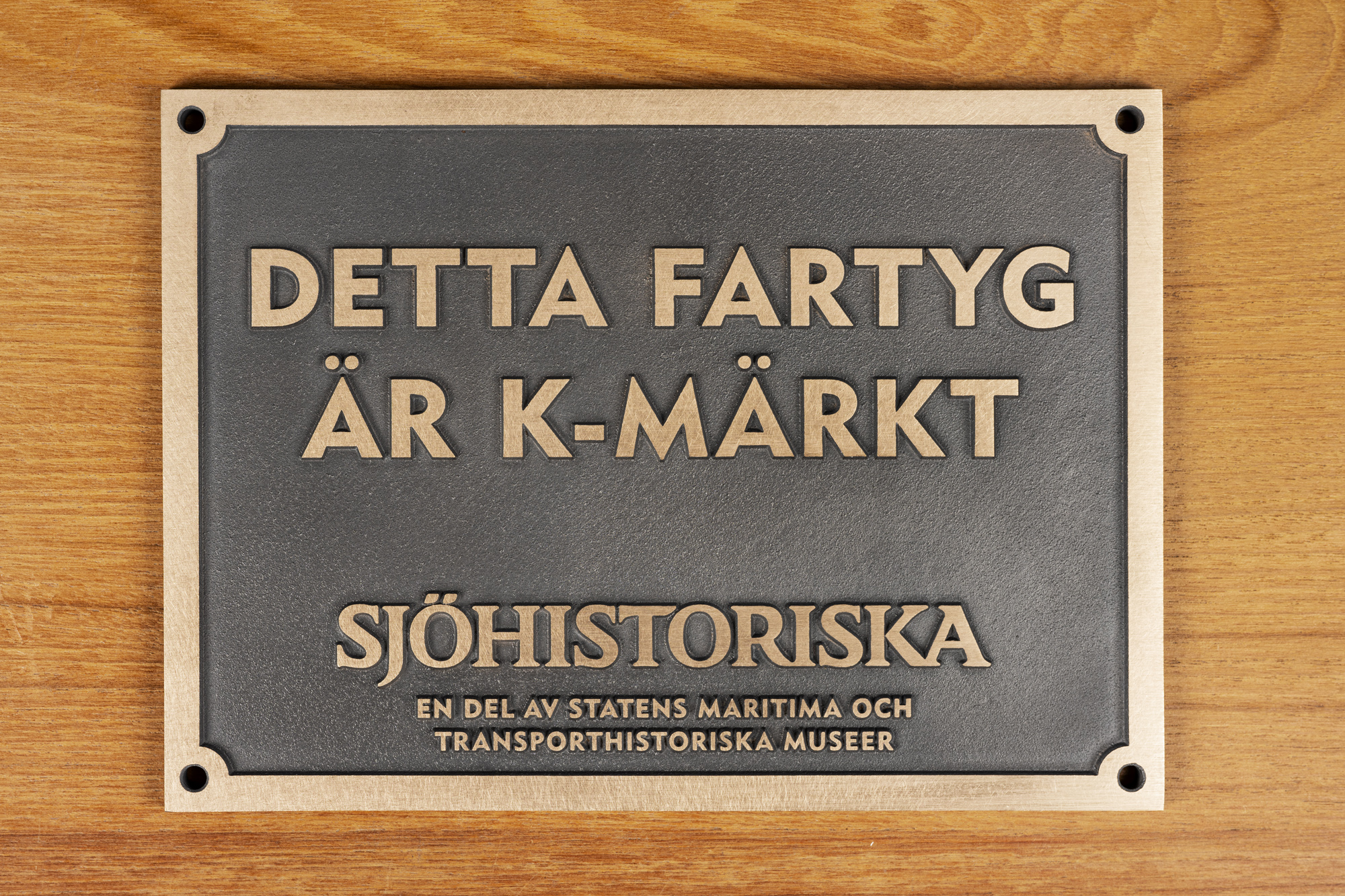 En bild på en bronsskylt med texten: Detta fartyg är k-märkt. 