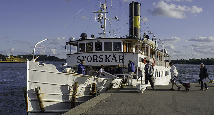 Storskär är ett vitmålat passagerarångfartyg med salonger på två däck, varav den övre med kommandobrygga i fören. På taket skymtas en livräddningsbåt och en svart skorsten. På bilden ligger fartyget vid en brygga i Stockholms skärgård och tar upp passagerare.  