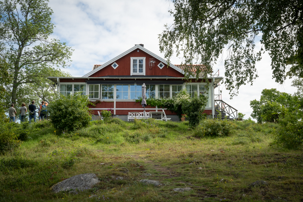 Ett rött hus med vita knutar står i grönska. Byggnaden var tidigare ett kolerasjukhus.